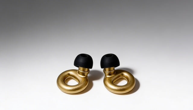 Gold and black earbud components on a gray background