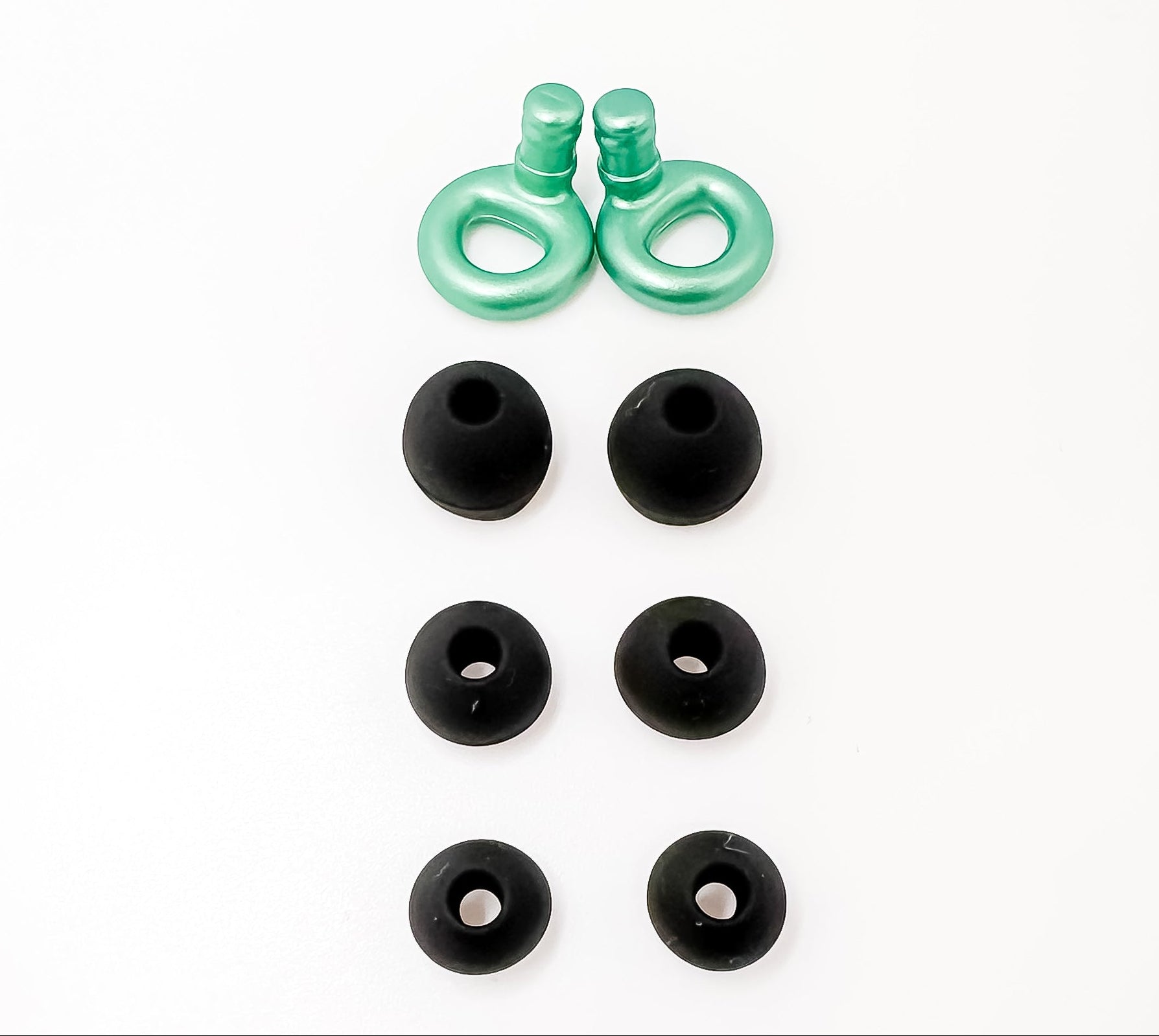 Green earbud tips and black rubber earbuds on a white background