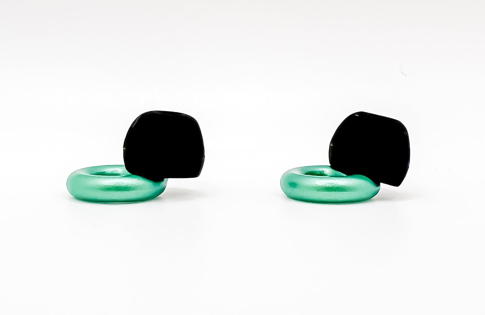 Pair of black and green earbuds on a white background