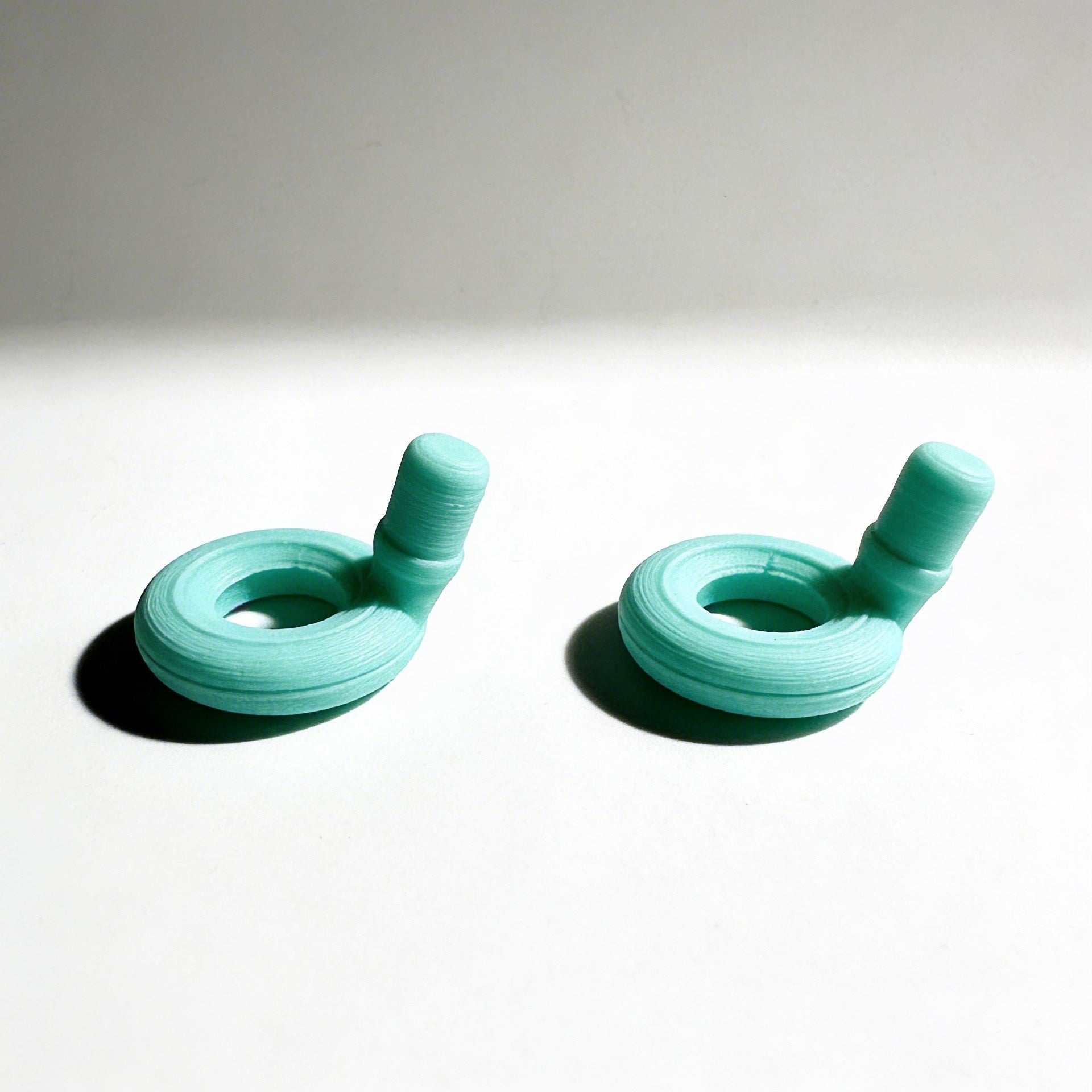 Pair of turquoise earbud tips on a light gray background
