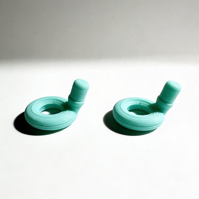 Pair of turquoise earbud tips on a light gray background