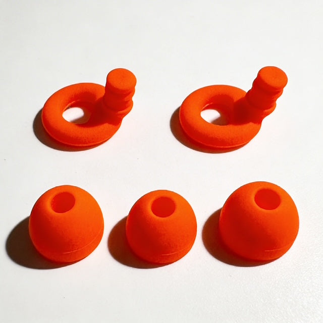 Set of orange silicone earbud tips on a white background
