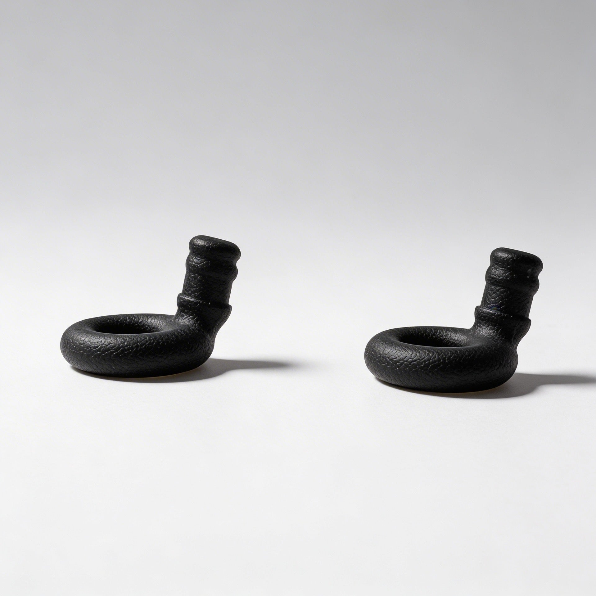 Two black rubber earbuds  on a white background