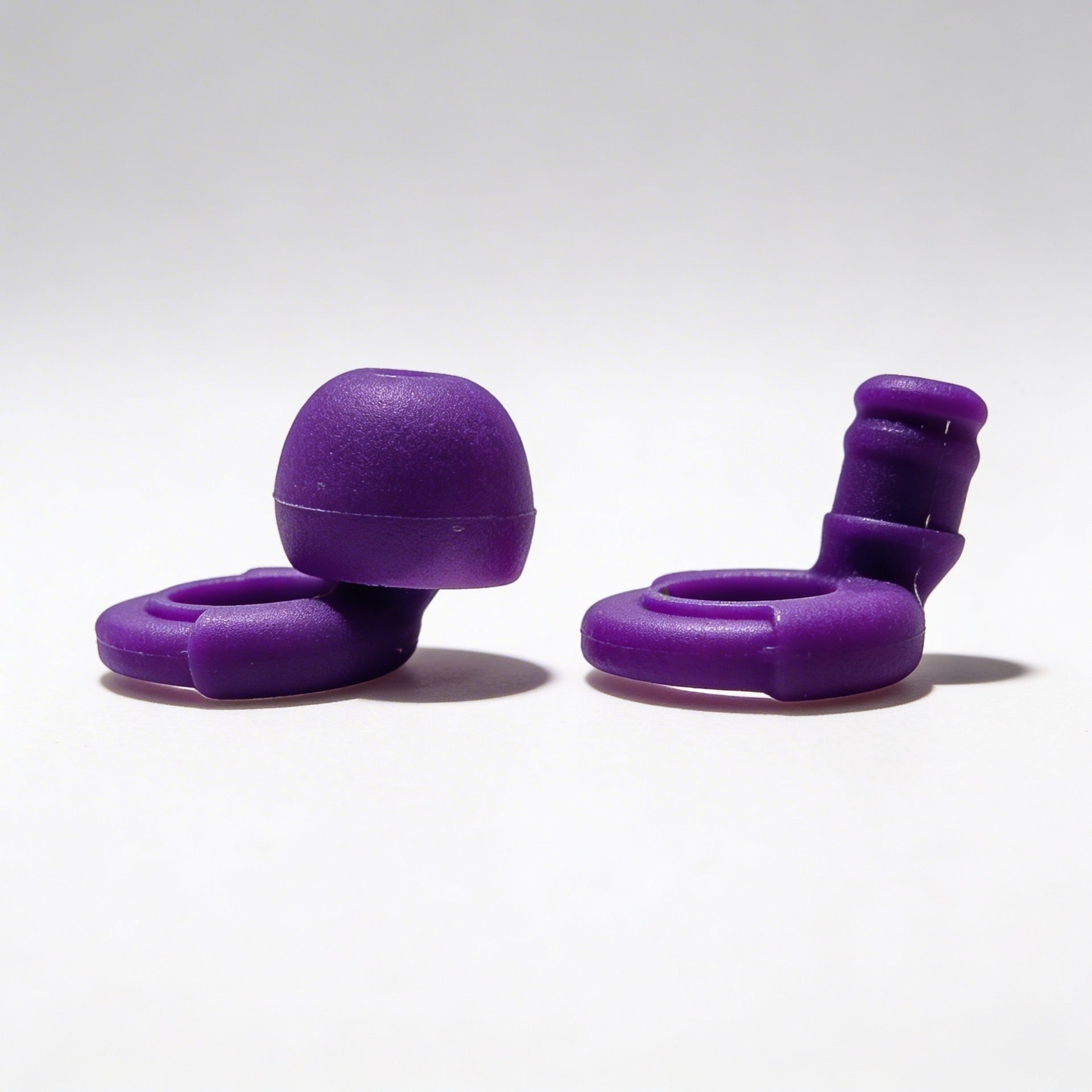 Two purple silicone ollybuds on a white background